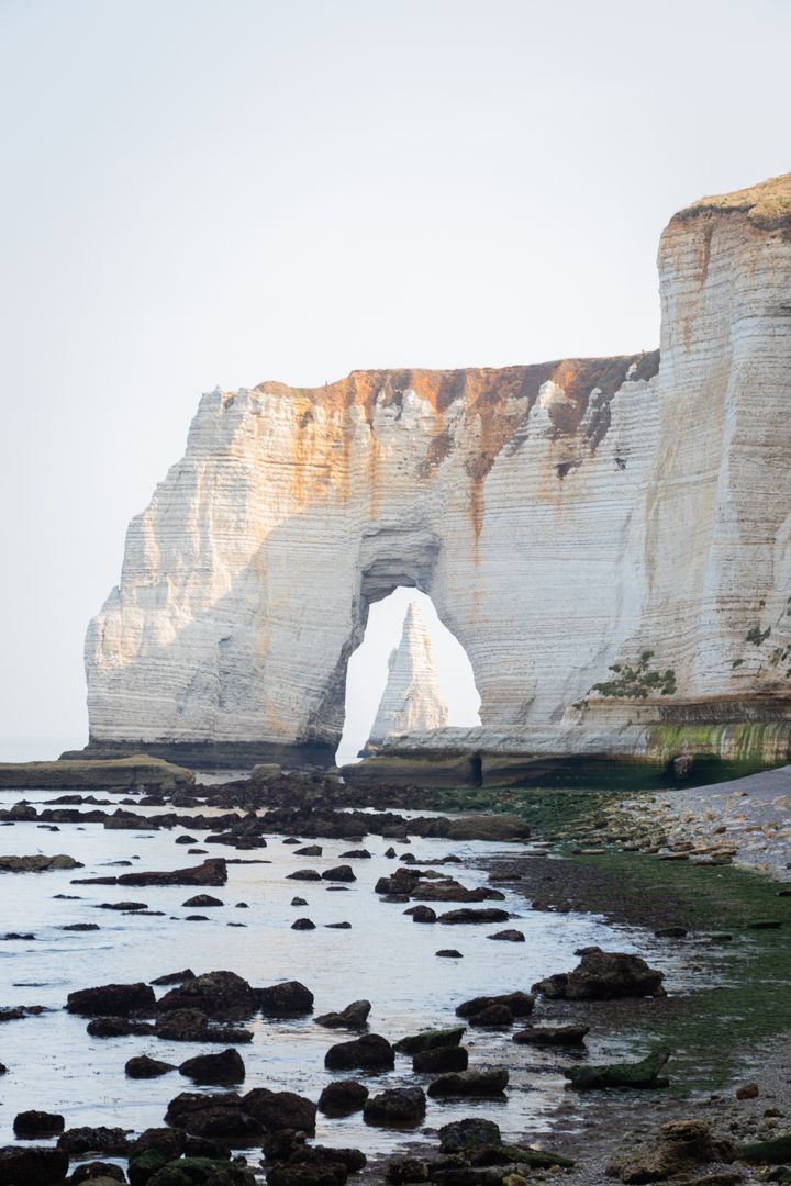 A white cliff with an arch in the middle.