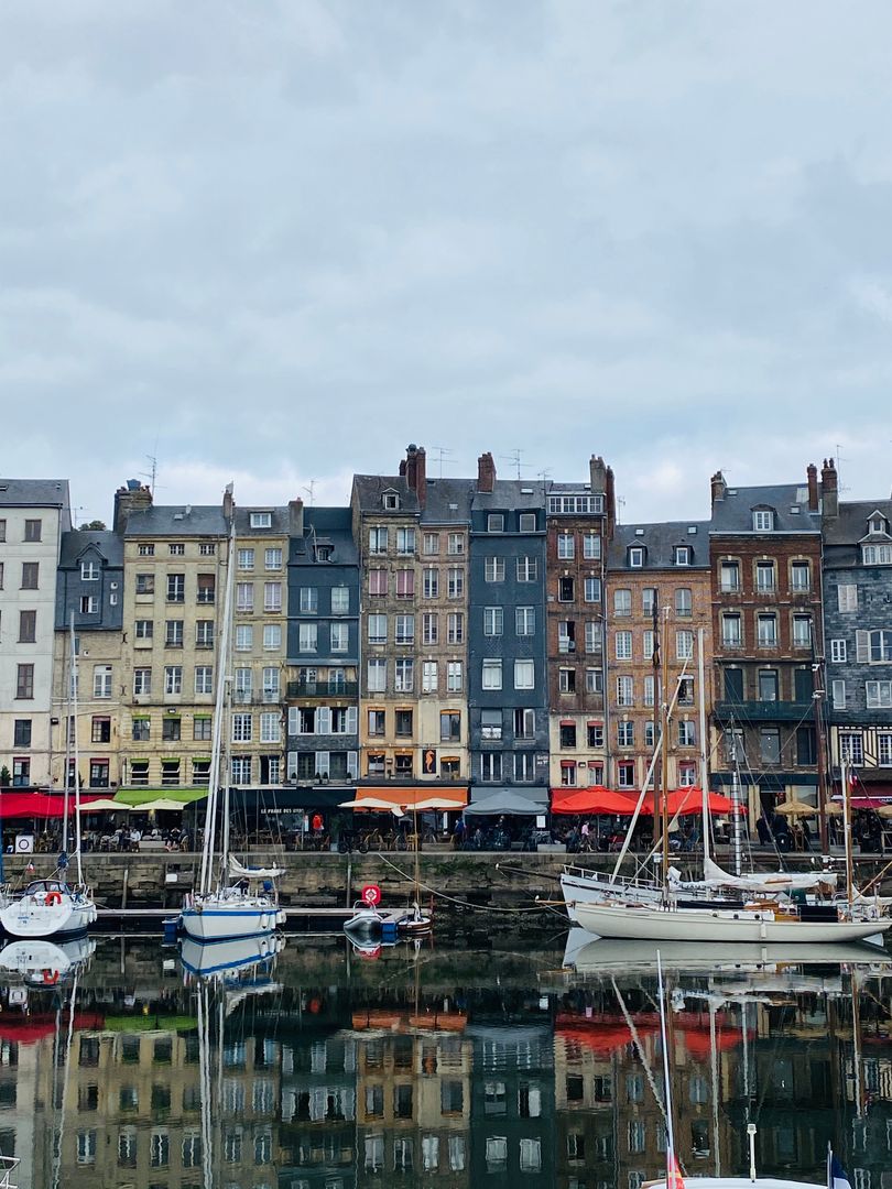 A row of buildings with boats docked in the water.