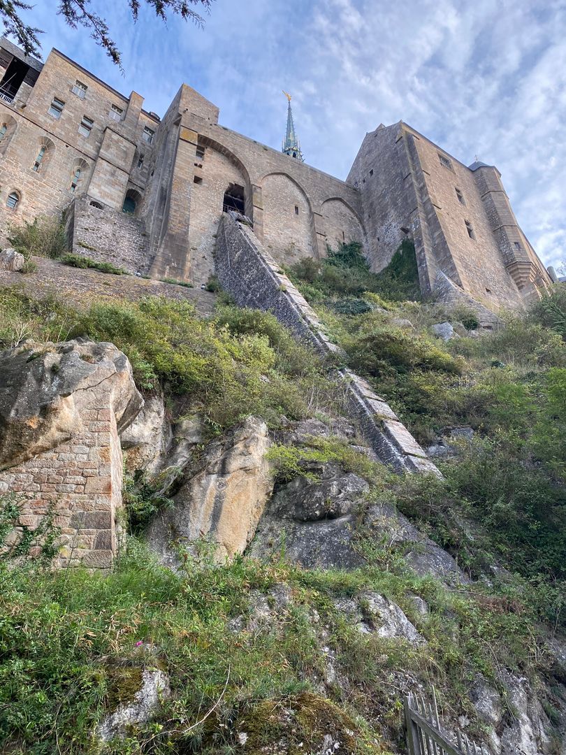 A castle sits on top of a rocky hill.