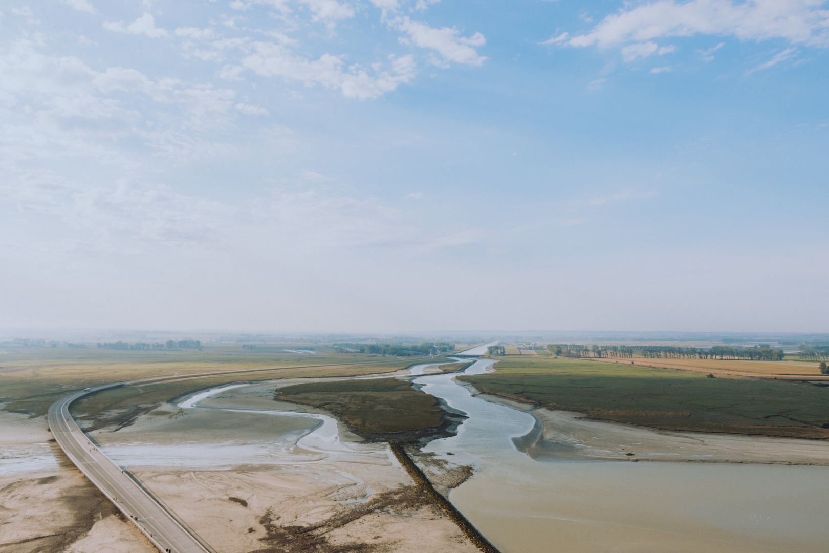 An aerial view of a river in a field.