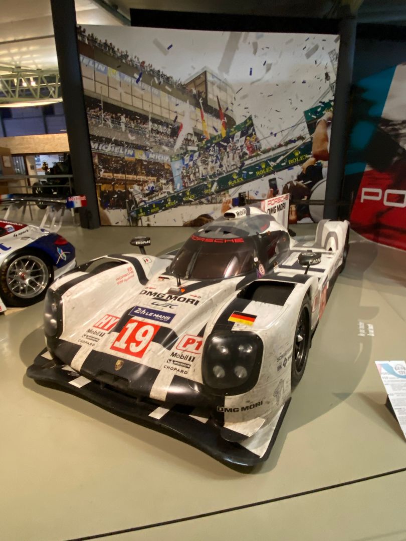 A porsche race car is on display in a museum.