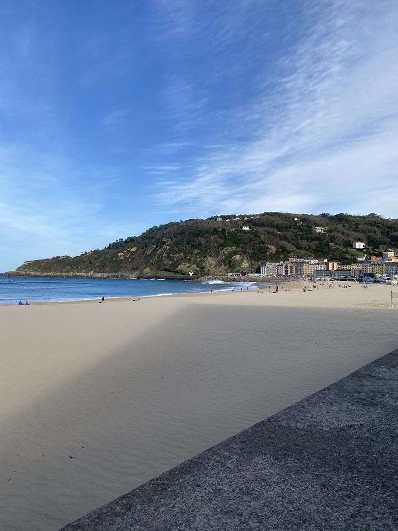 A beach with sand and a blue sky.