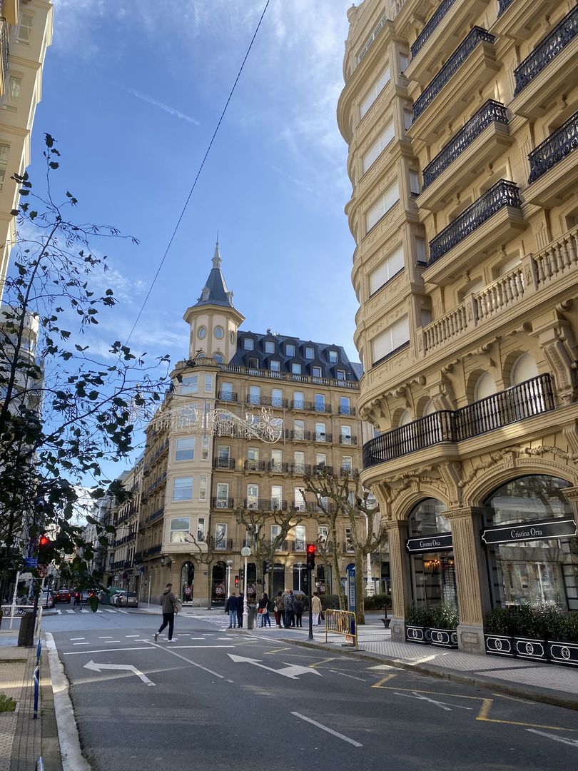 A city street with buildings and people walking down the street.