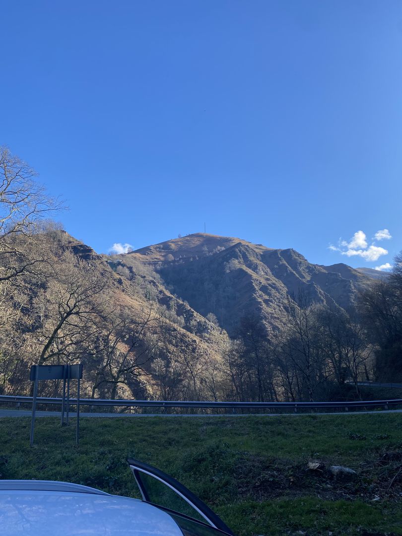 A car parked on a road with mountains in the background.