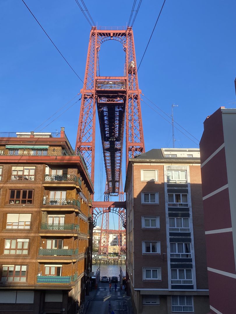 A view of a bridge over a city with buildings in the background.