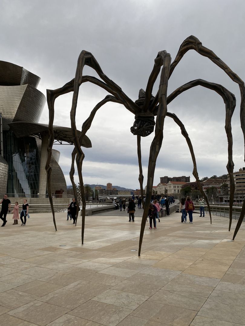 A large sculpture of a spider in front of a building.