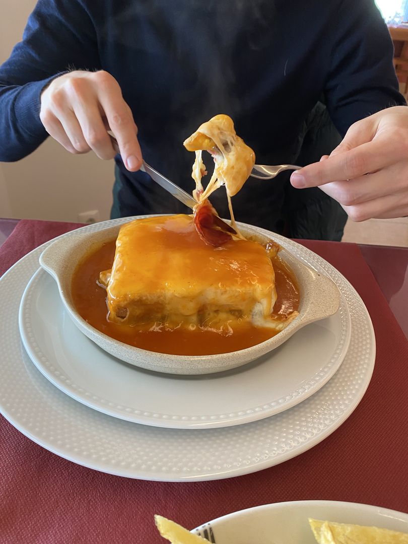A man is dipping his fork into a plate of food.