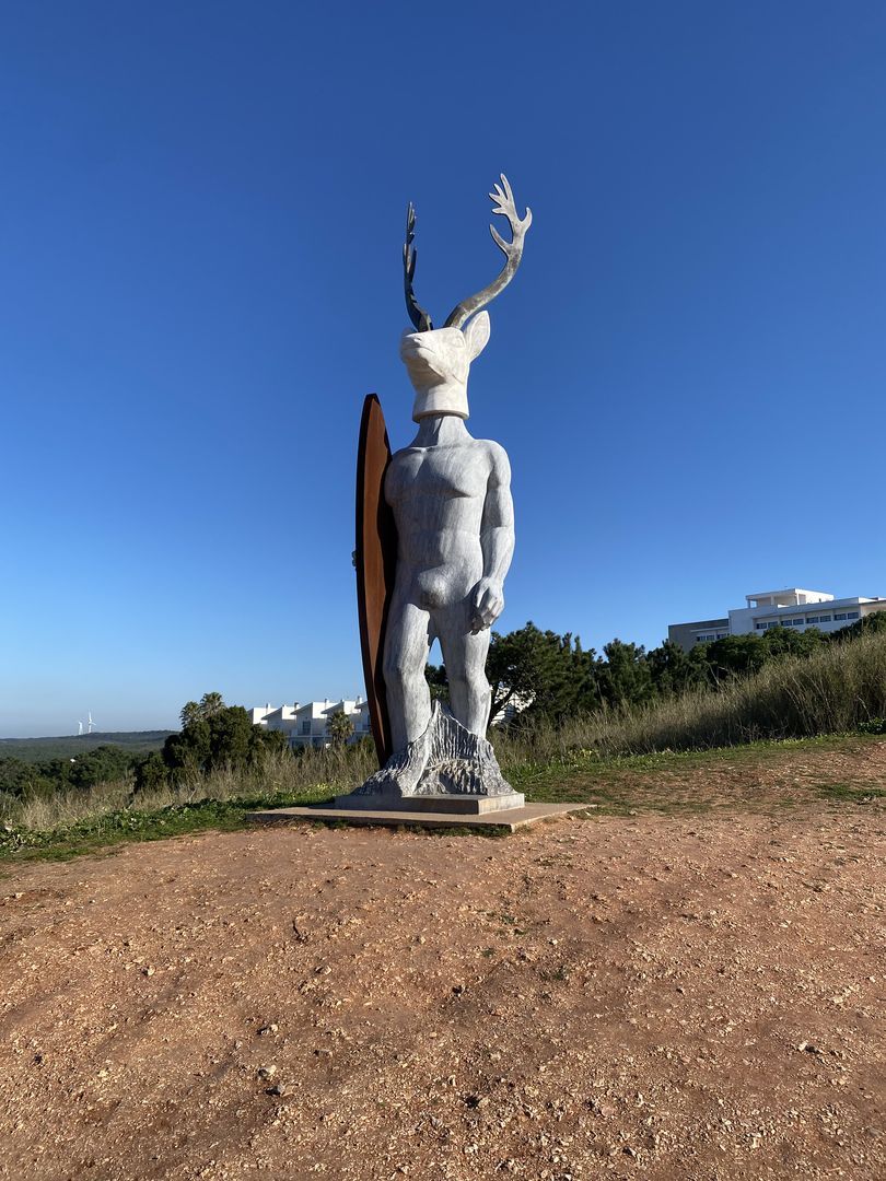 A statue of a deer standing on top of a hill.