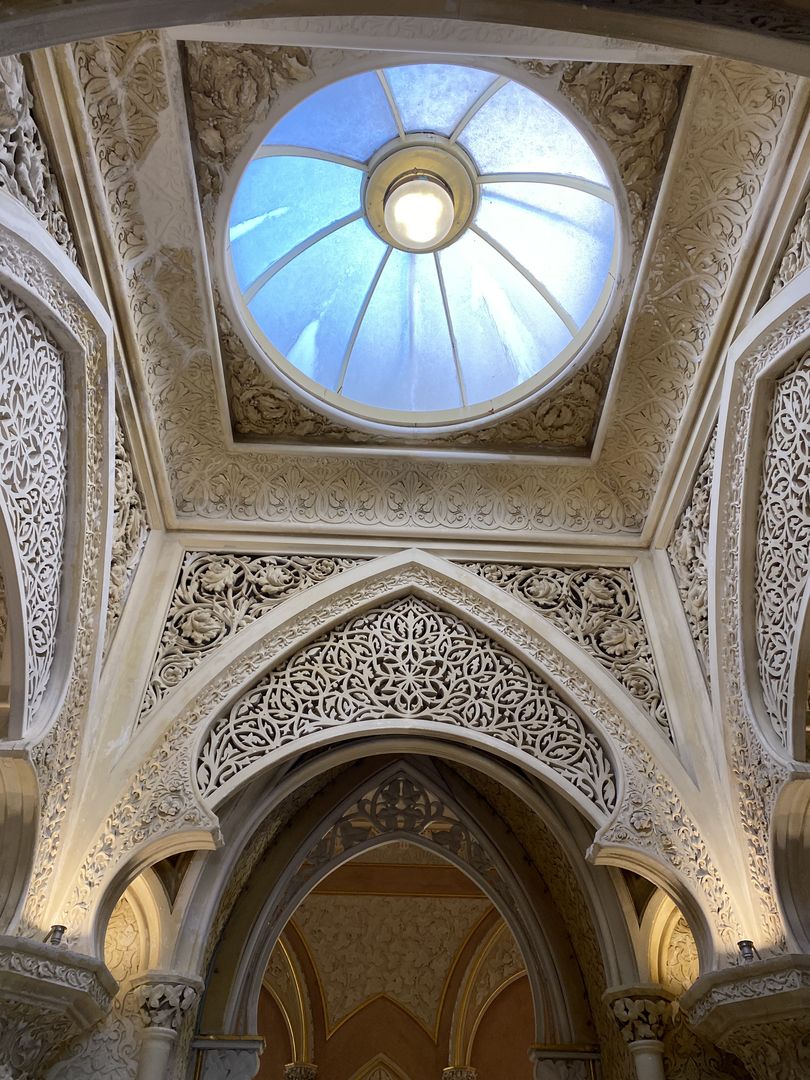 An ornate ceiling with a skylight.