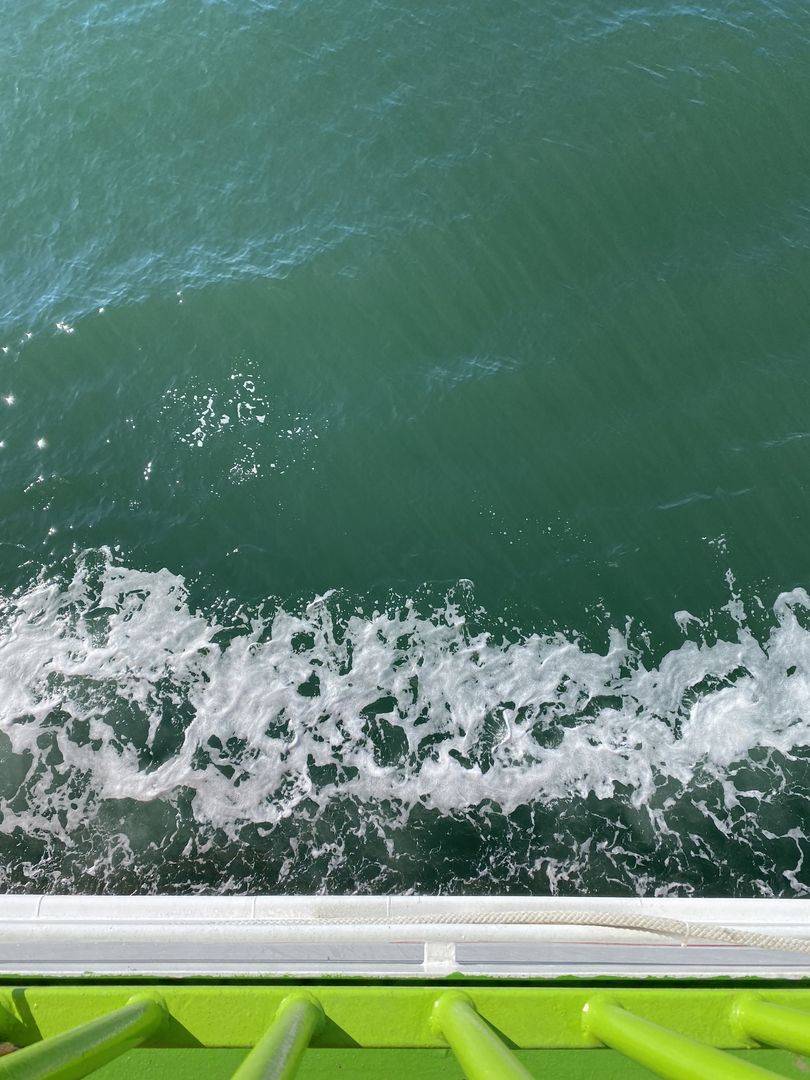 A view of the ocean from the deck of a boat.