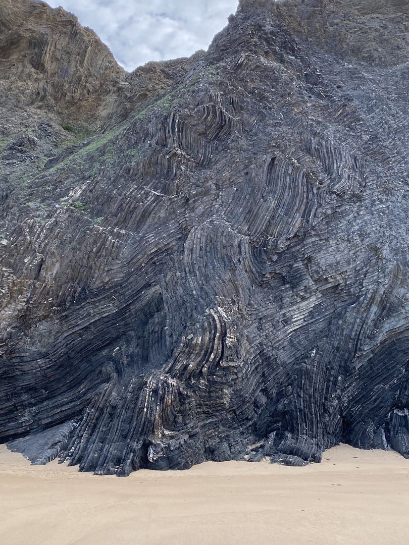 A large rock formation on a beach.