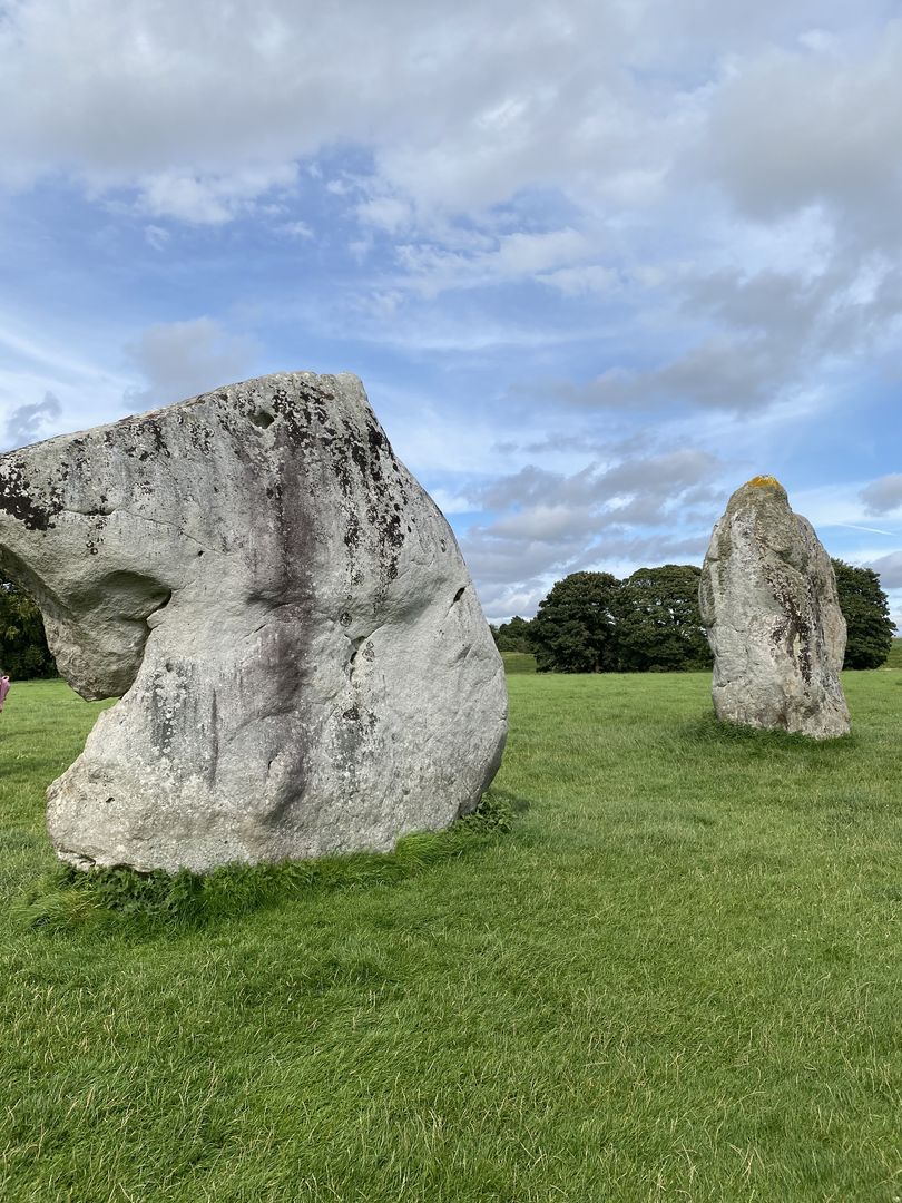 Three large stones in a grassy field.