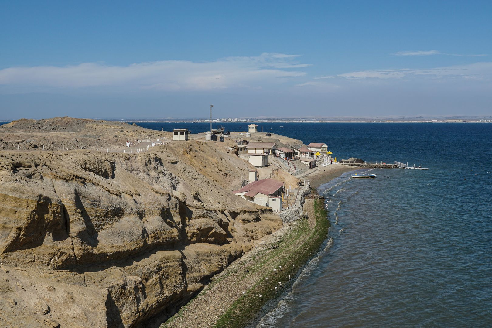 A cliff overlooking a body of water.