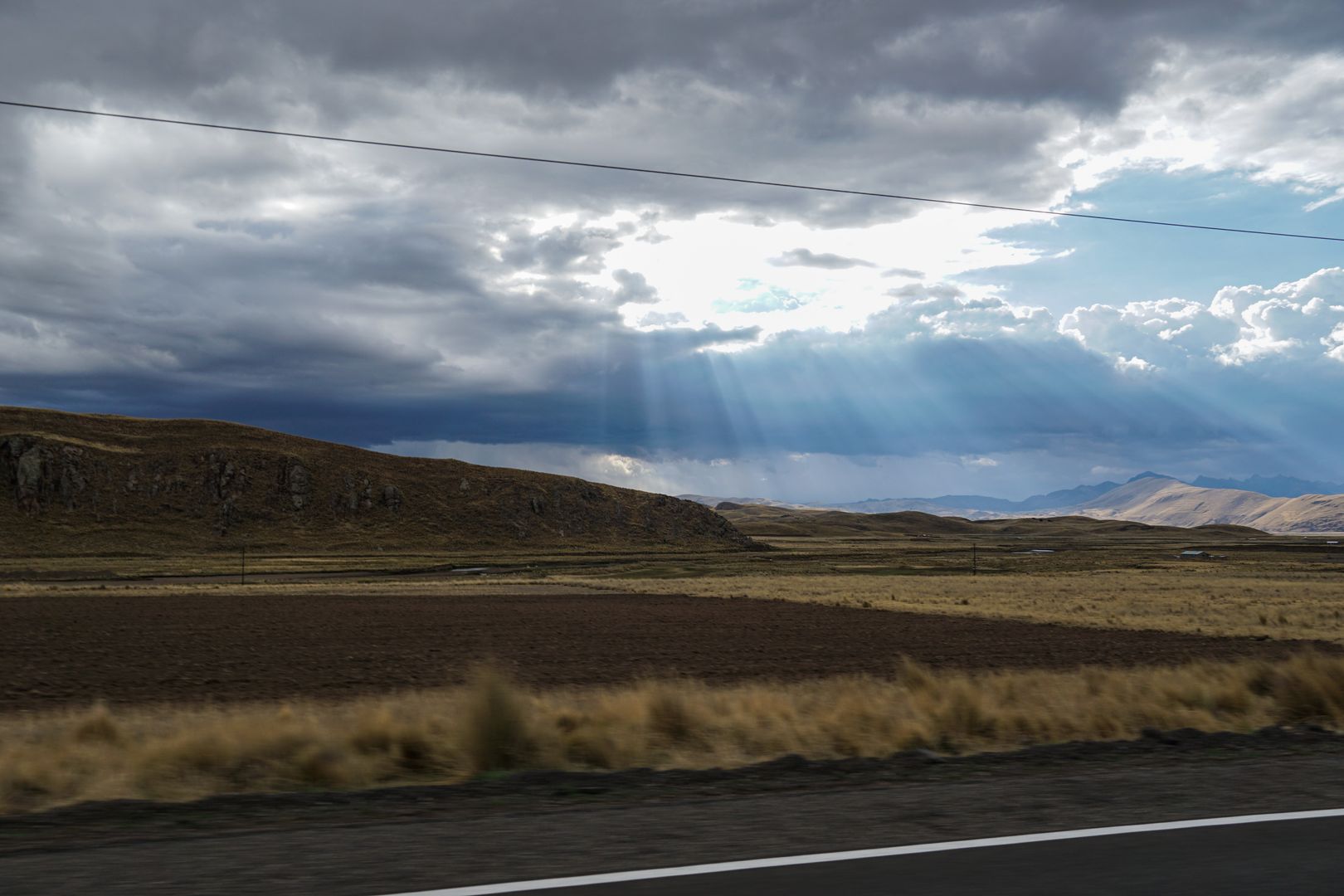The sun is shining through a cloudy sky.