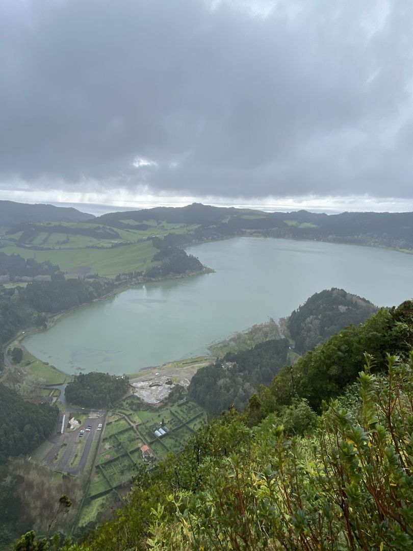 A view of a lake from the top of a hill.