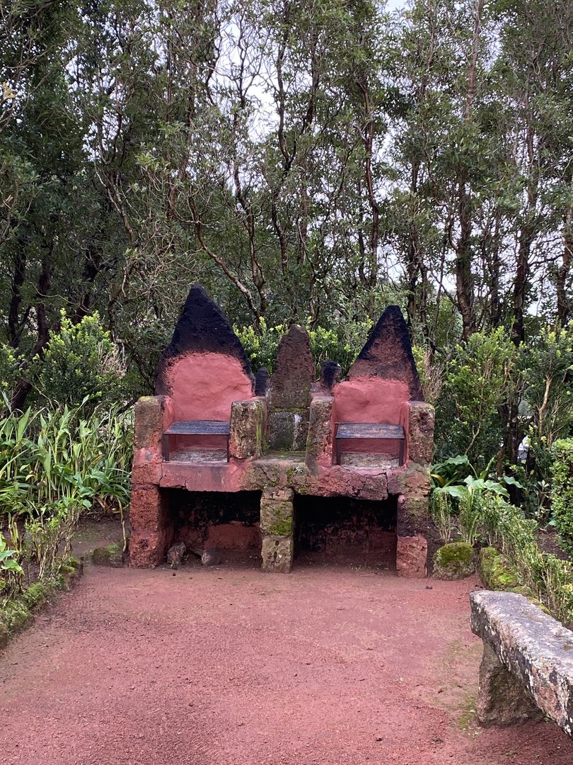 A red bench in the middle of a forest.